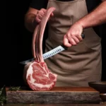 person-holds-a-sharp-knife-over-large-cut-of-meat